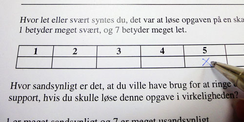 En test-person sætter kryds i et tilfredshedsmålingsskema